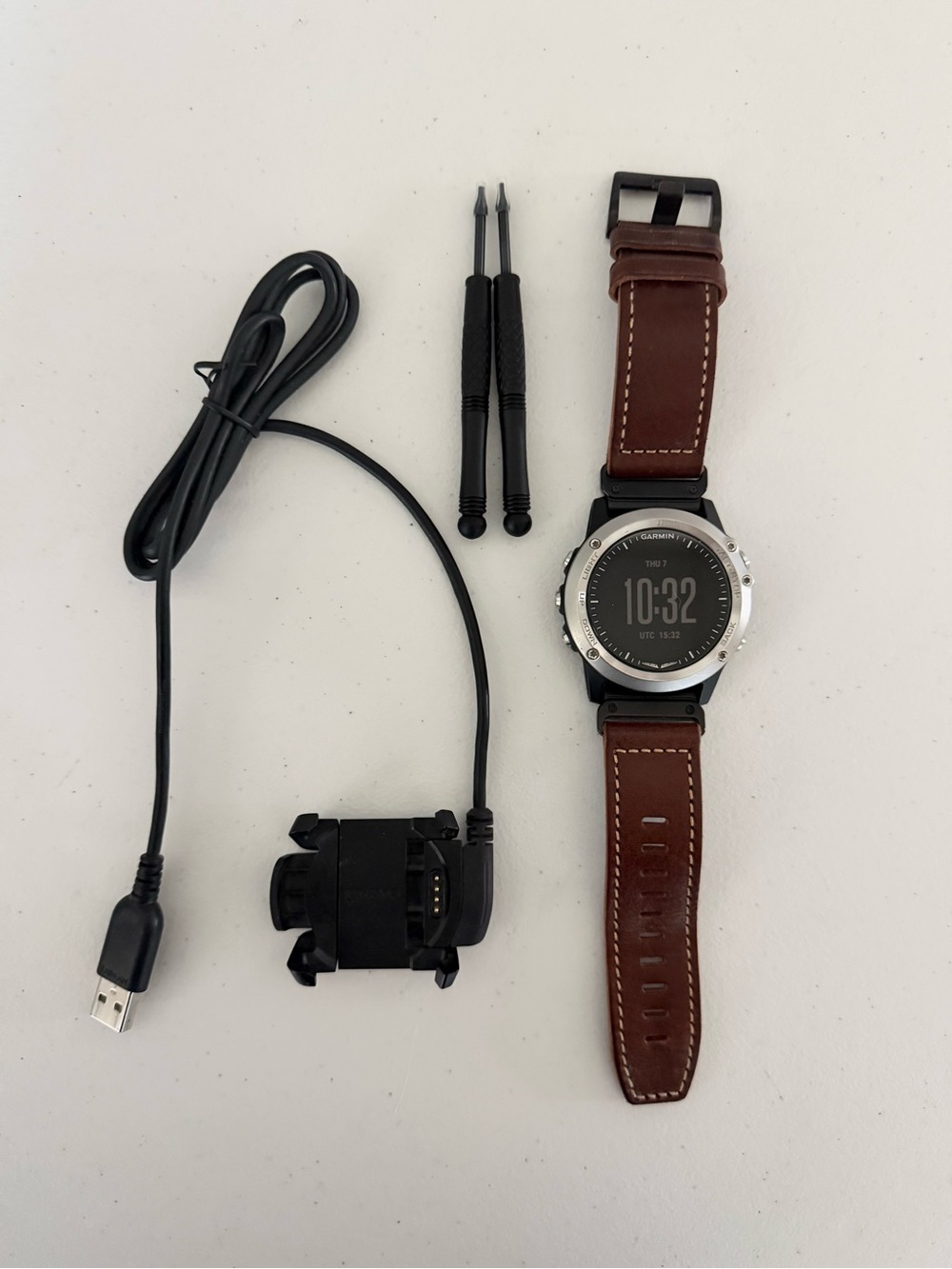 garmin smartwatch with brown leather band and silver bezel